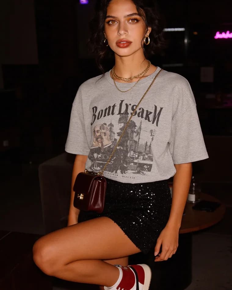 Sam con playera gris en un interior de noche